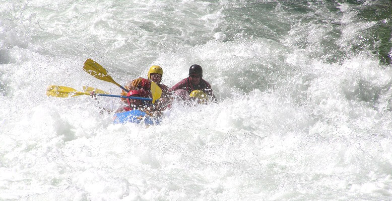 Two people are in a raft on the water.