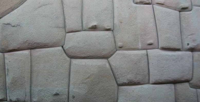 A close up of the stone wall with some small holes.