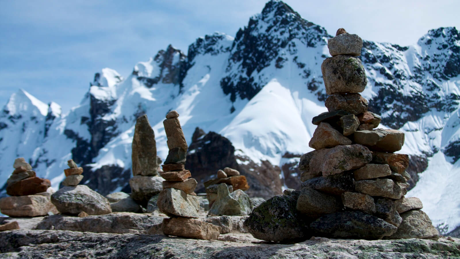 A group of rocks stacked up in front of a mountain.