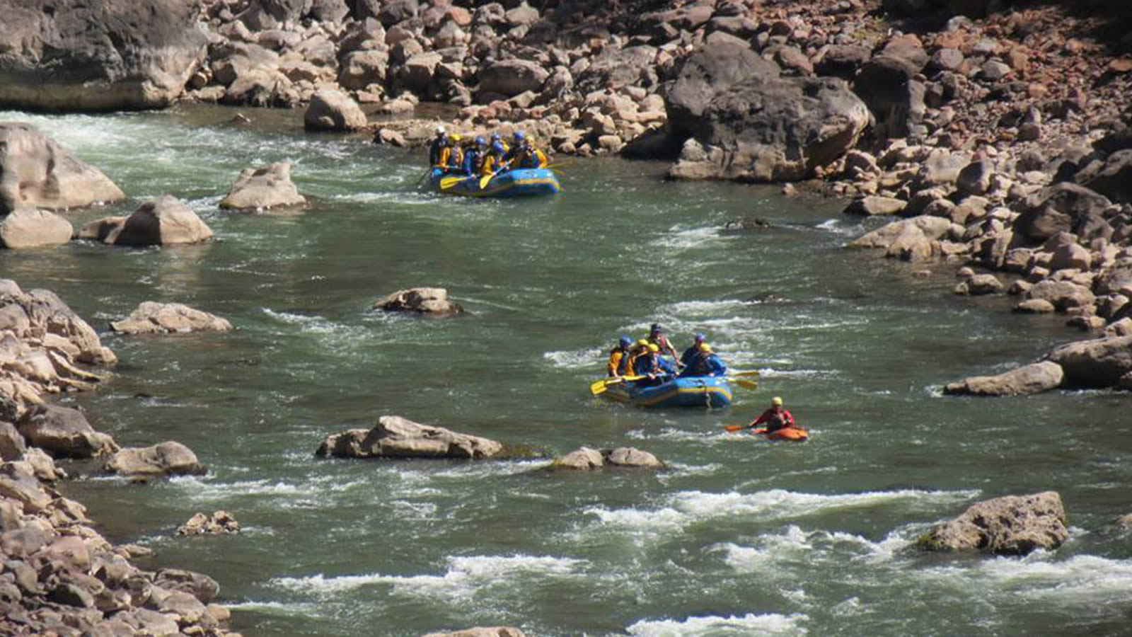 A group of people in rafts on the river.