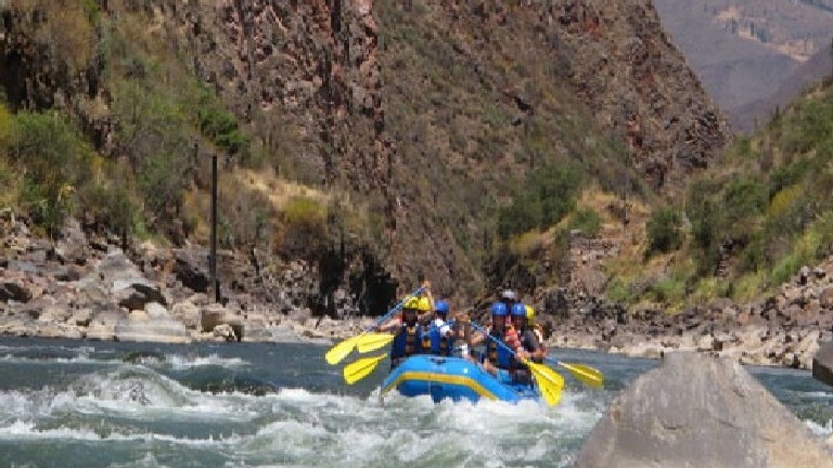 A group of people in a raft on the river.