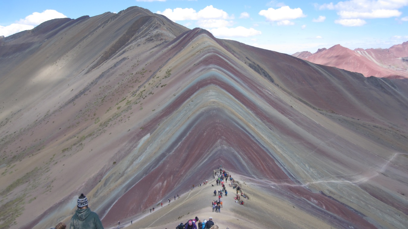 A group of people walking up the side of a mountain.