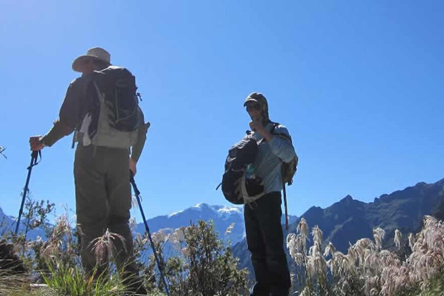 Hikers with backpacks enjoy mountain vista.