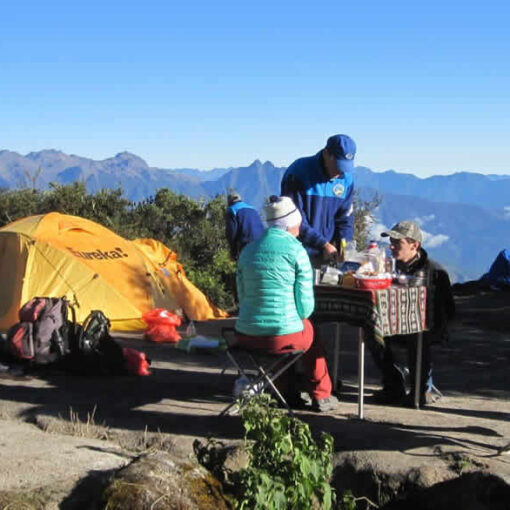 Hikers enjoying a meal with mountain views.