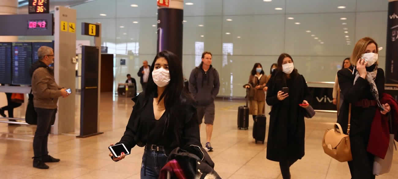 Masked travelers at an airport.